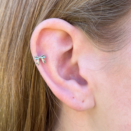 Close-up of an ear with a small bow flatback earring
